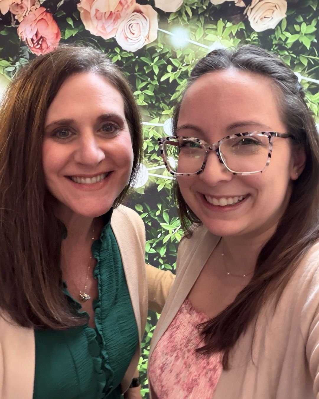 Jennifer Fitzgerald and Amanda Morang in front of a floral wall at BLOOM
